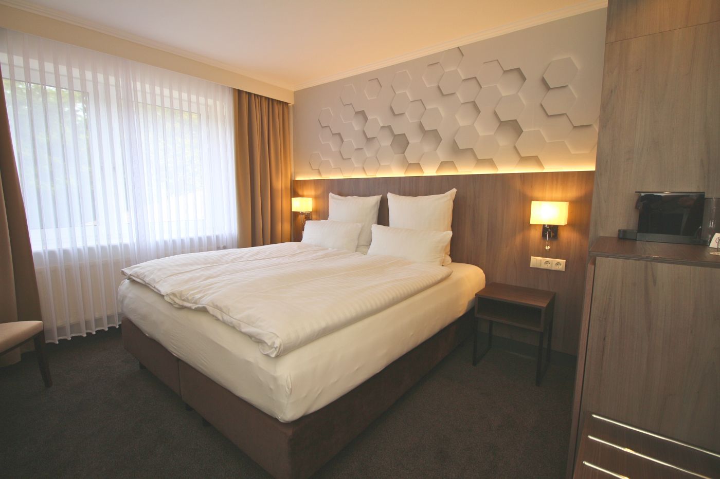 Doppelzimmer „Lütt un fien“ im Hotel Esterwegen mit Boxspringbett und Blick in den Garten